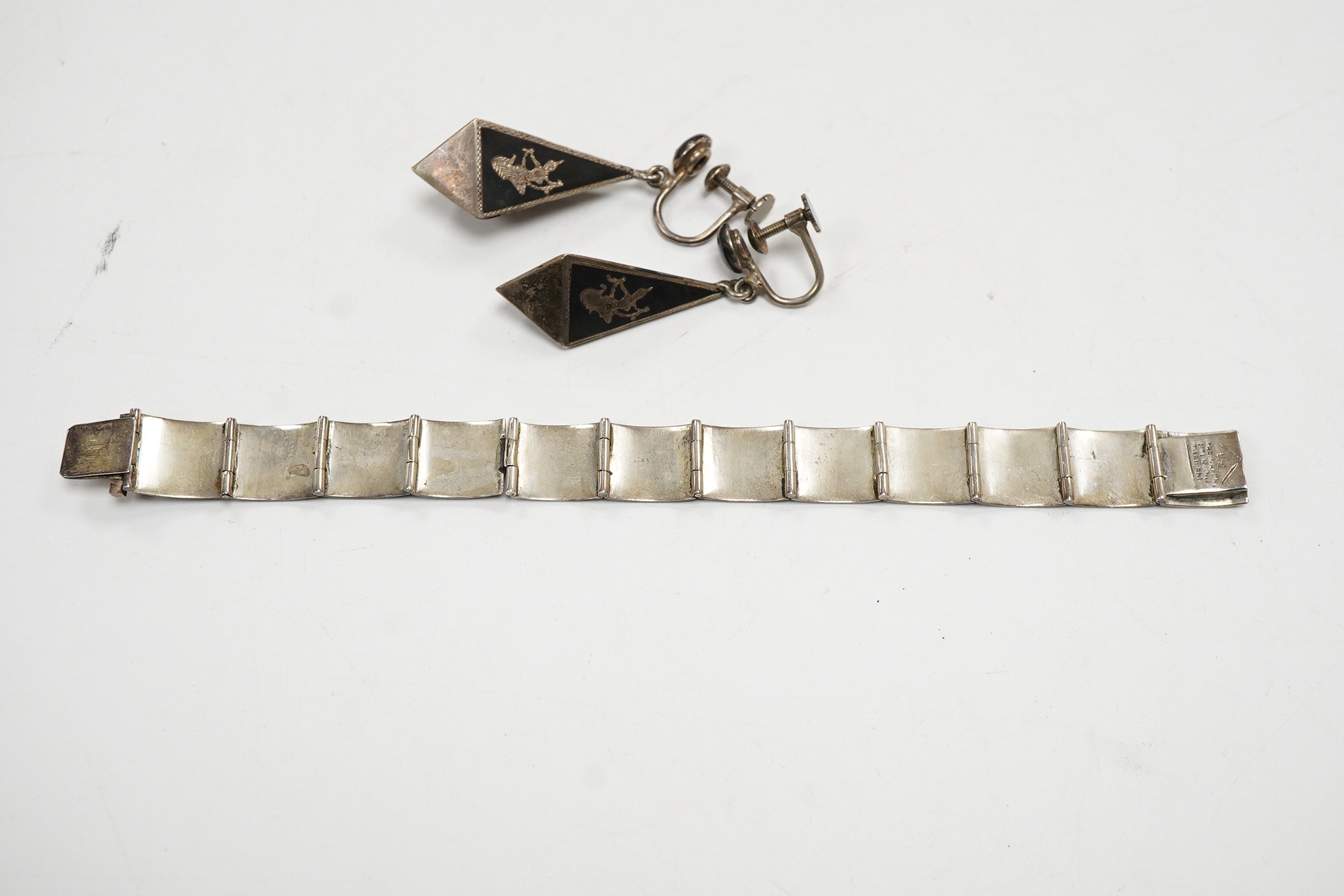 A Thai sterling and niello bracelet, 16.2cm, together with a pair of similar earrings.